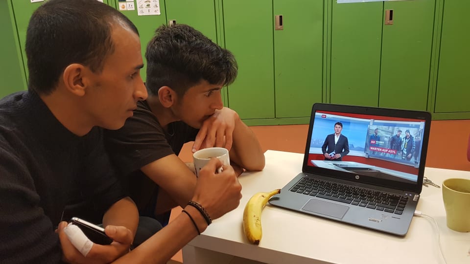Zwei junge Männer schauen Video