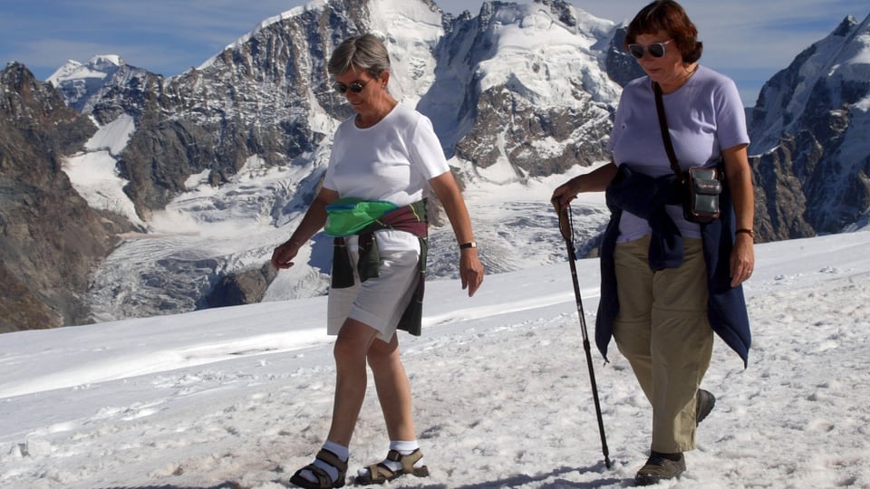 Zwei ältere Frauen auf Schnee gehend