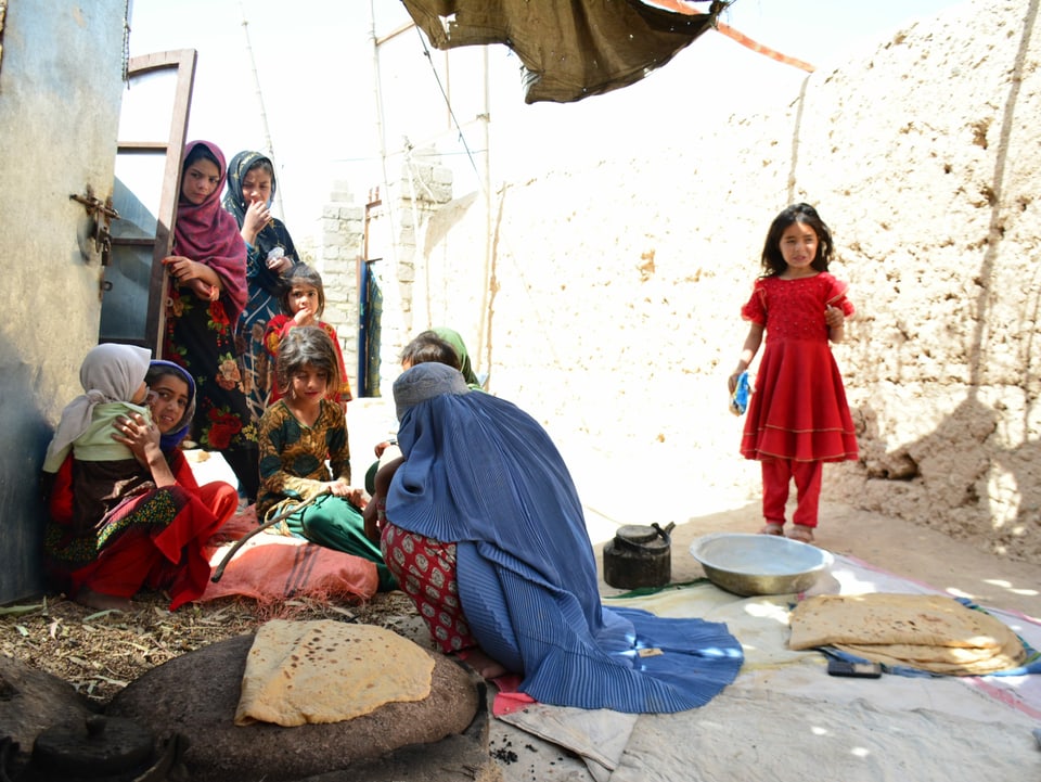 Shekiba (vorne Mitte) backt vor ihrer Hütte afghanisches Fladenbrot für die Familie. 