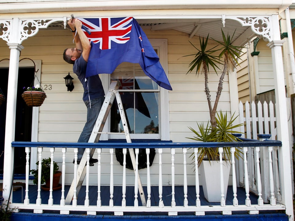 Ein Rugy-Fan hängt vor seinem Hauseingang die Flagge Neuseelands auf. 