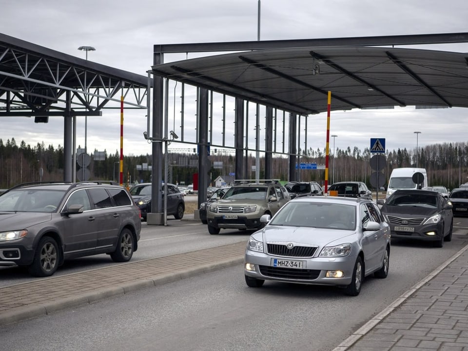 Ein Grenzposten zwischen Finnland und Russland. Auf der Strasse fahren Autos.