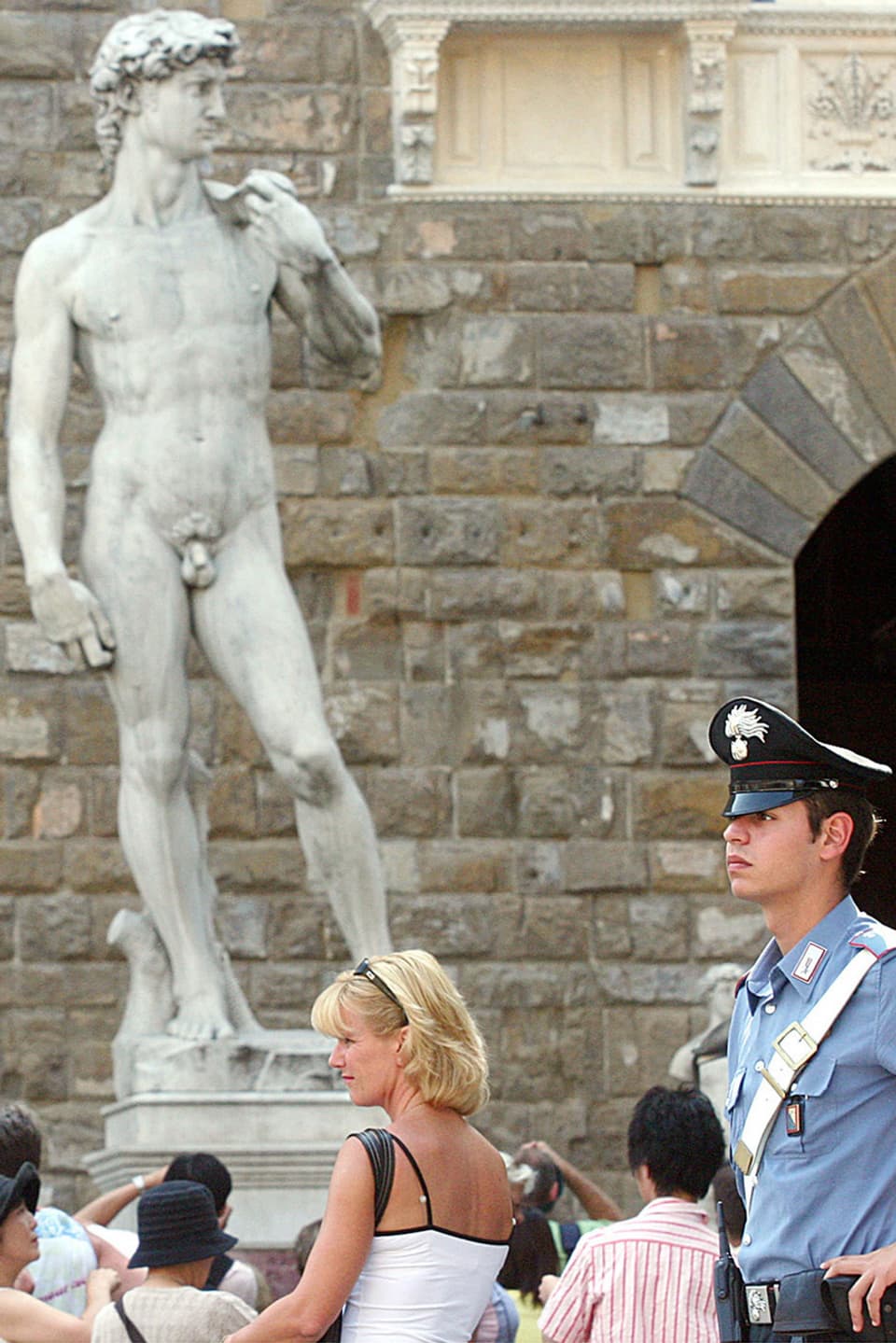 David von Michelangelo in Florenz, davor Touristinnen und ein Polizist.