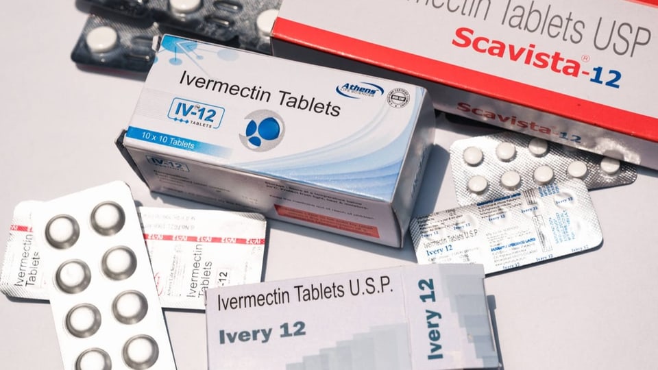 Verschiedene Ivermectin-Packungen und Pillen liegen nebeneinander