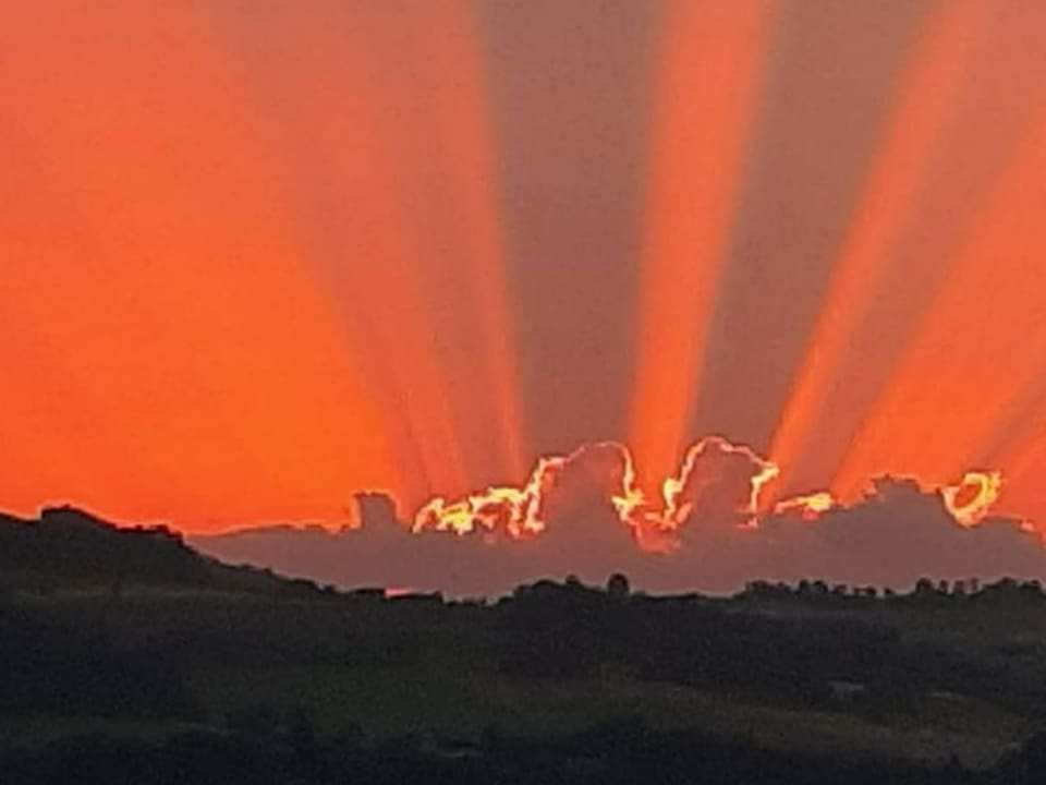 Strahlenbündel der Sonne hinter einer Wolke.