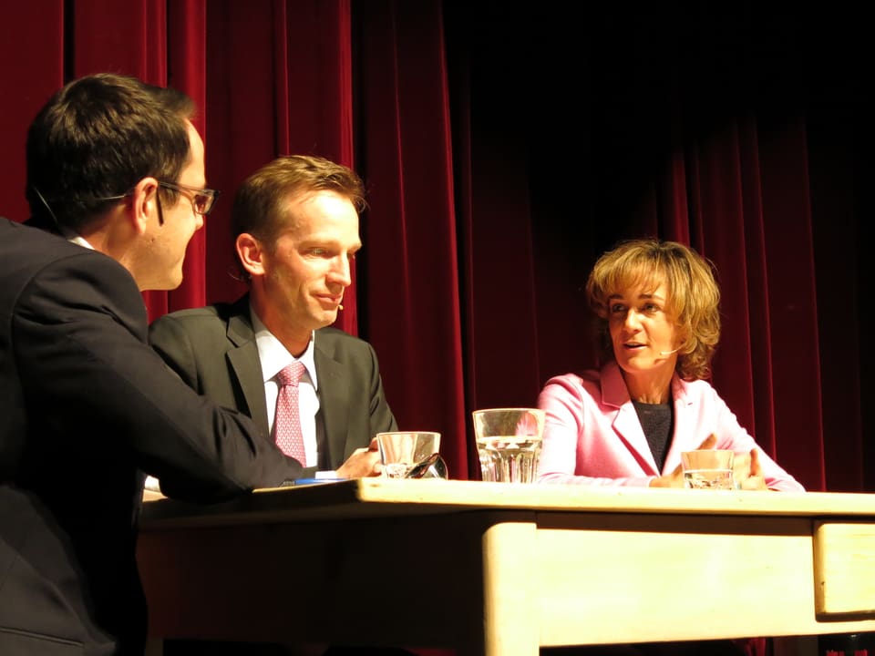 Thomas Pressmann, Alexandre Schmidt und Ursula Wyss am Tisch auf dem Podium