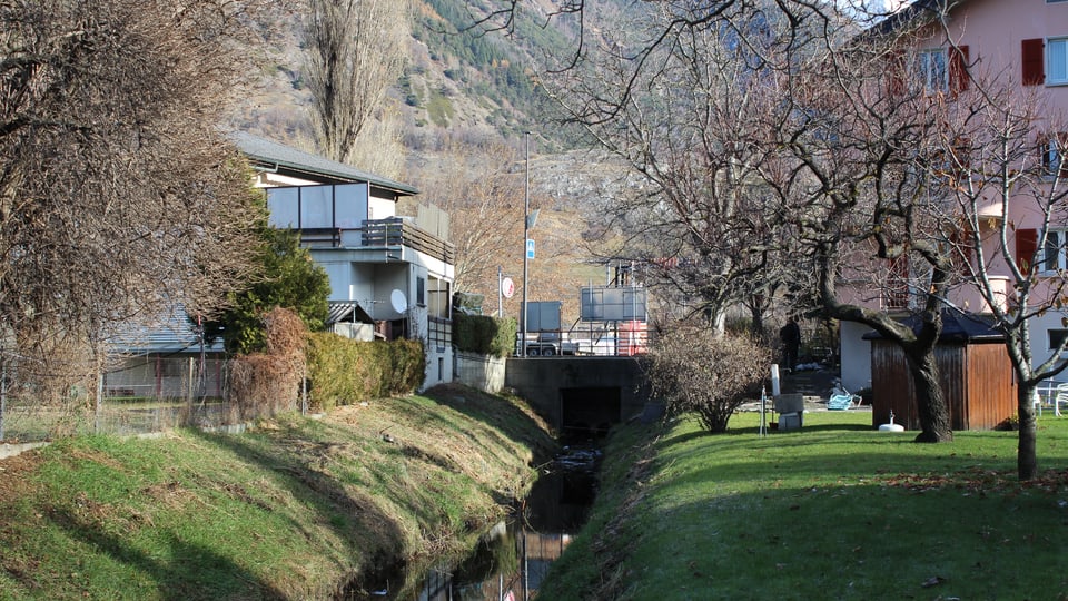 Ein Kanal zwischen Häusern, im Hintergrund eine Brücke.