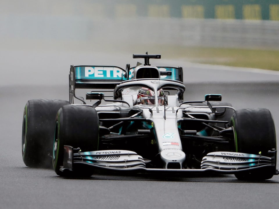 Lewis Hamilton lenkt seinen Boliden über die nassen Strassen.