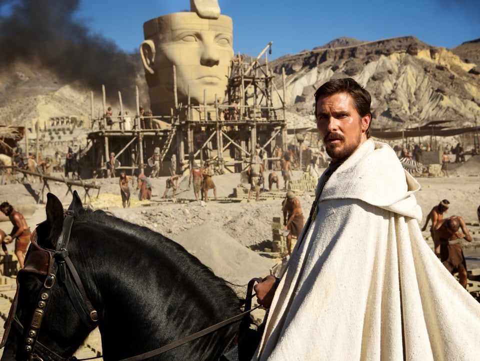 Schauspieler Christian Bale als Moses. Er sitzt in einem weissen Gewand auf dem Pferd.