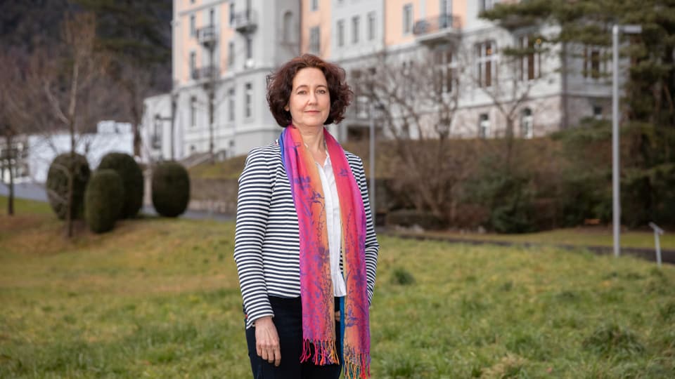 Eine Frau vor einem grossen Gebäude.