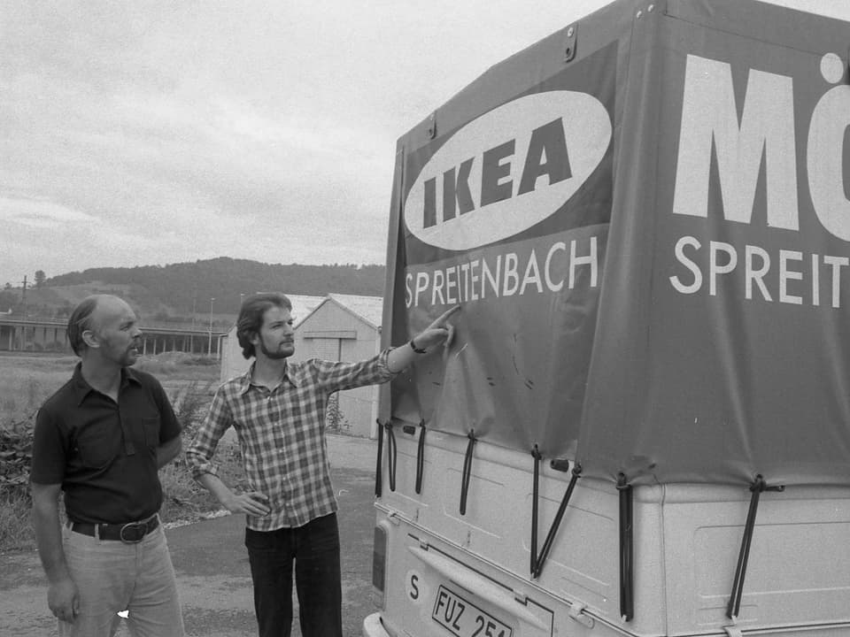 Zwei Ikea-Mitarbeiter stehen vor einem Transporter.
