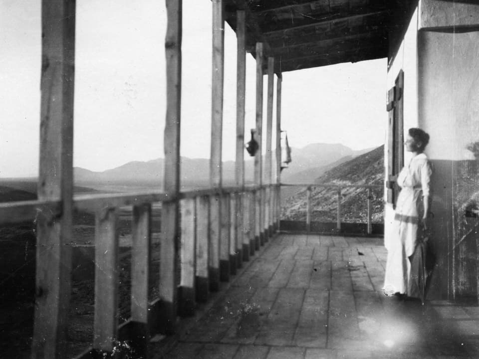 Altes foto einer Frau, die auf einer Veranda steht. 
