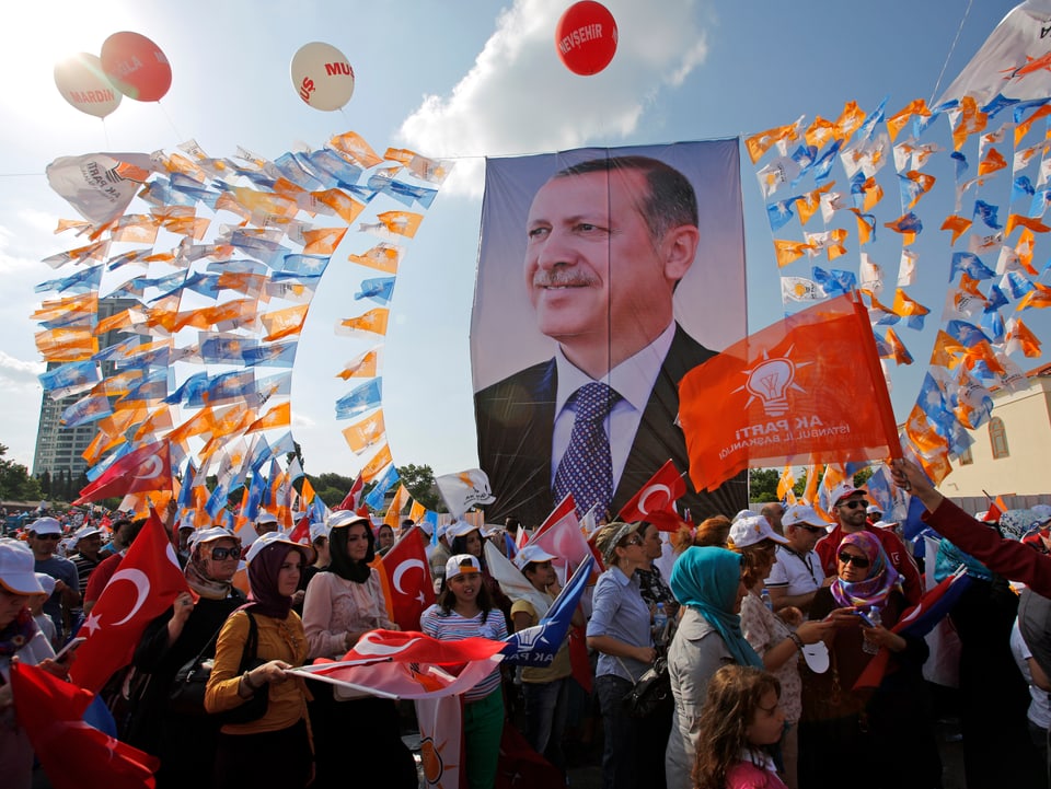 Demonstranten mit roten Fahnen, buten Wimpeln in einem Portrait von Premier Erdogan.