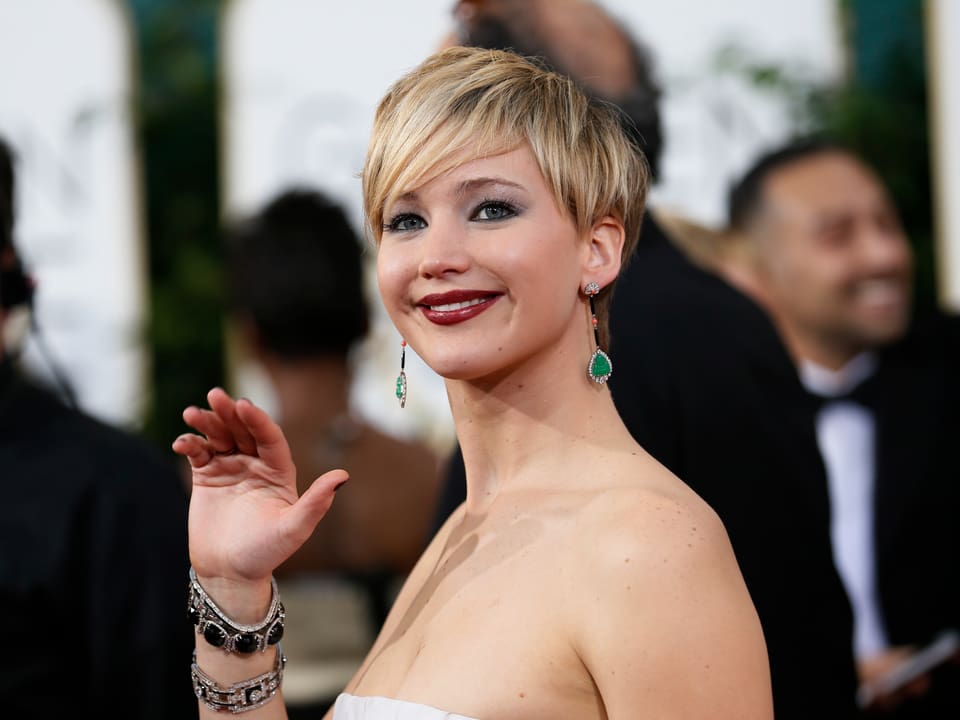 Schauspielerin Jennifer Lawrence winkt in die Kamera.