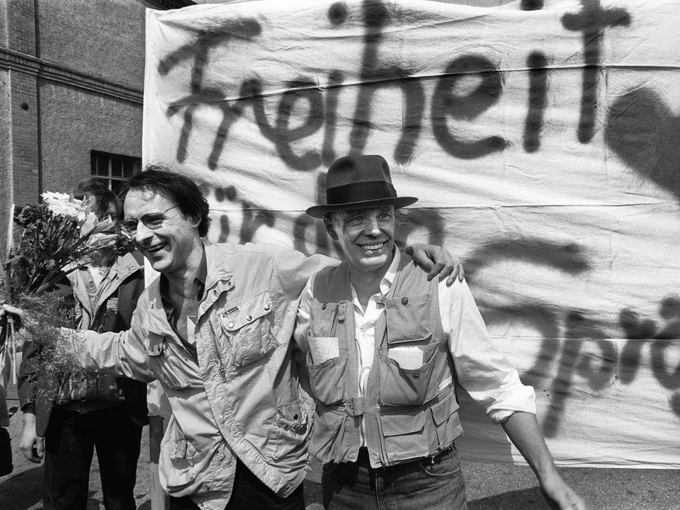 Am 24. April 1984 kommt Naegeli (links) zurück in seine Heimat und wird den Behörden ausgeliefert. Beim Grenzübertritt in Lörrach bei Basel wird der Sprayer von der Kulturszene gefeiert, Künstler Joseph Beuys (rechts) unterstützt ihn. 