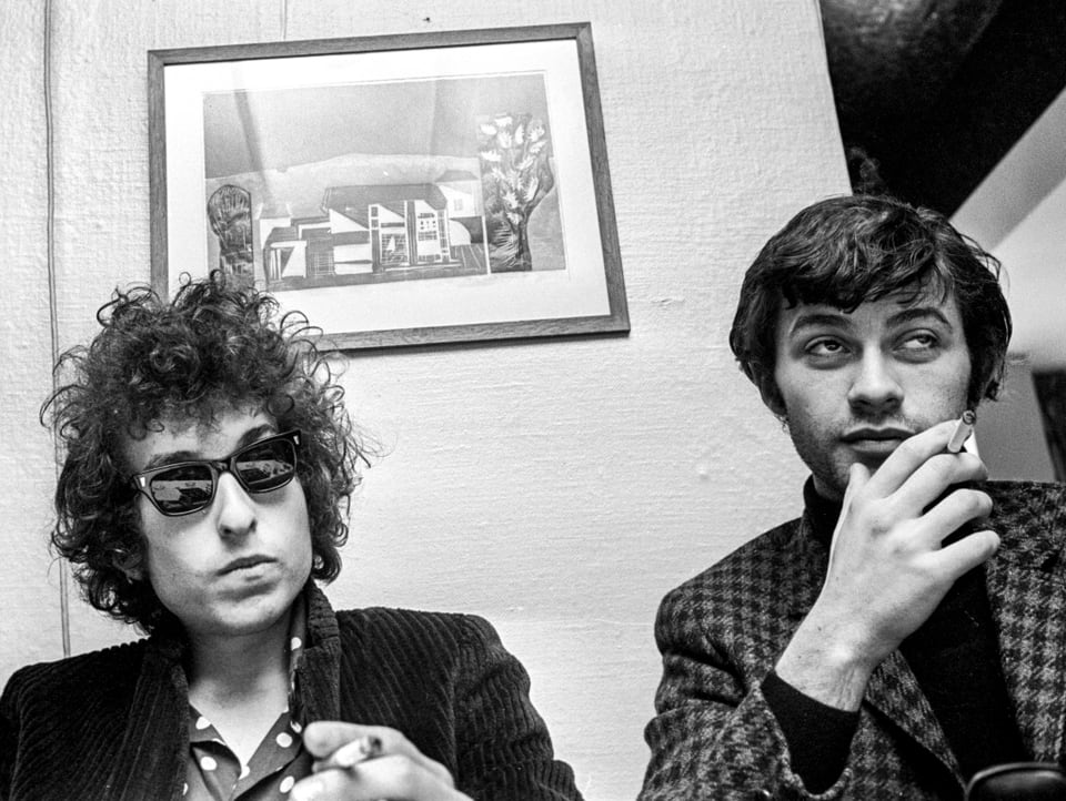Bob Dylan und Robbie Robertson sitzen zusammen an einem Tisch.
