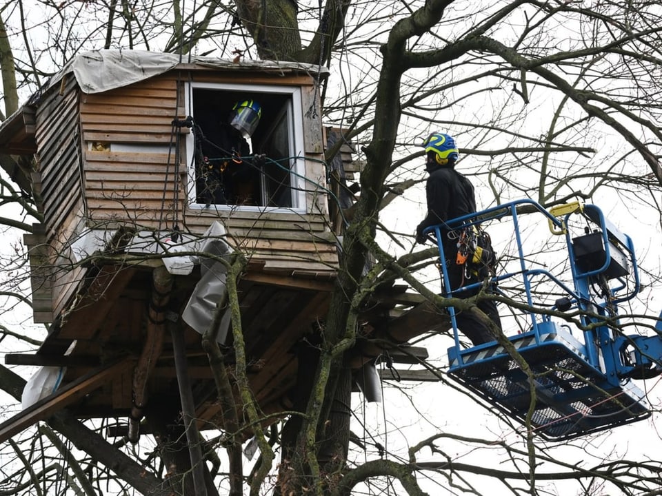 Zwei Polizisten räumen ein Baumhaus in Lützerath.