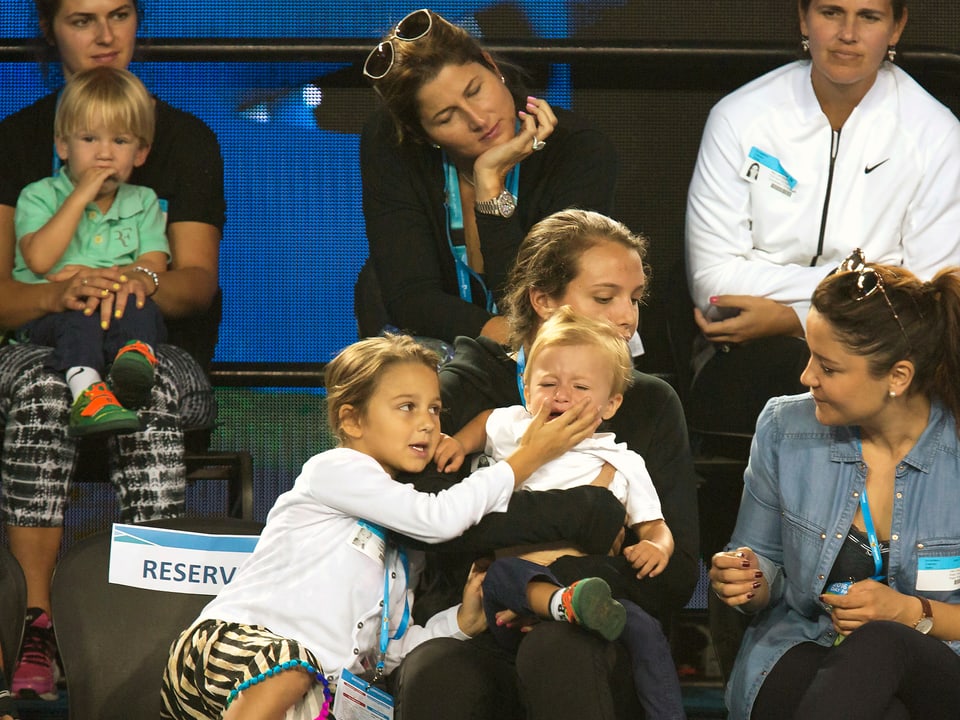Familie Federer auf der Tribüne. Ein Junge weint, die Schwester hält ihm die Hand vor den Mund.