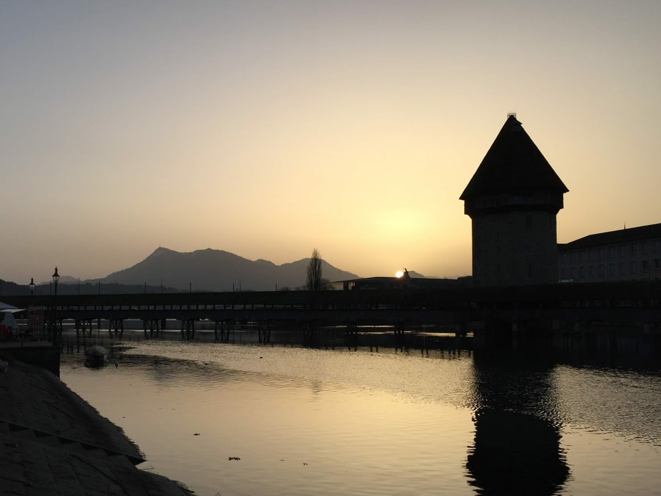 Luzern Kappelbrücke mit Turm über Reuss in der gelben Dämmerung