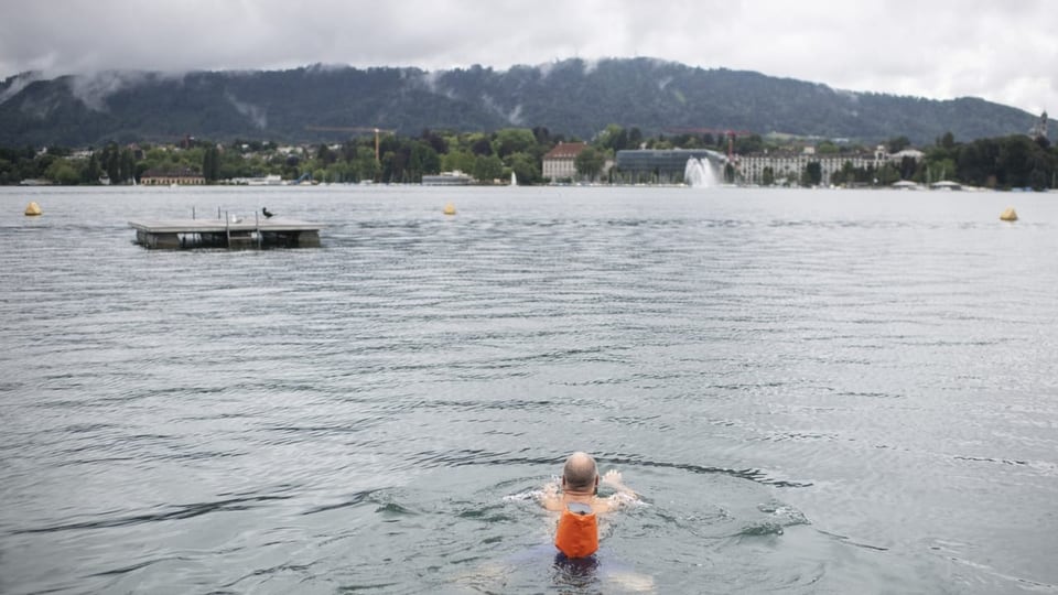 Ein Mann schwimmt im Zürichsee im Seebad Utoquai. 