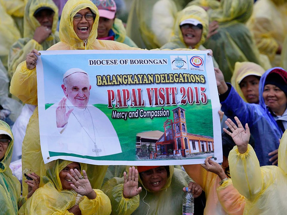 Gläubige mit Papst-Plakaten