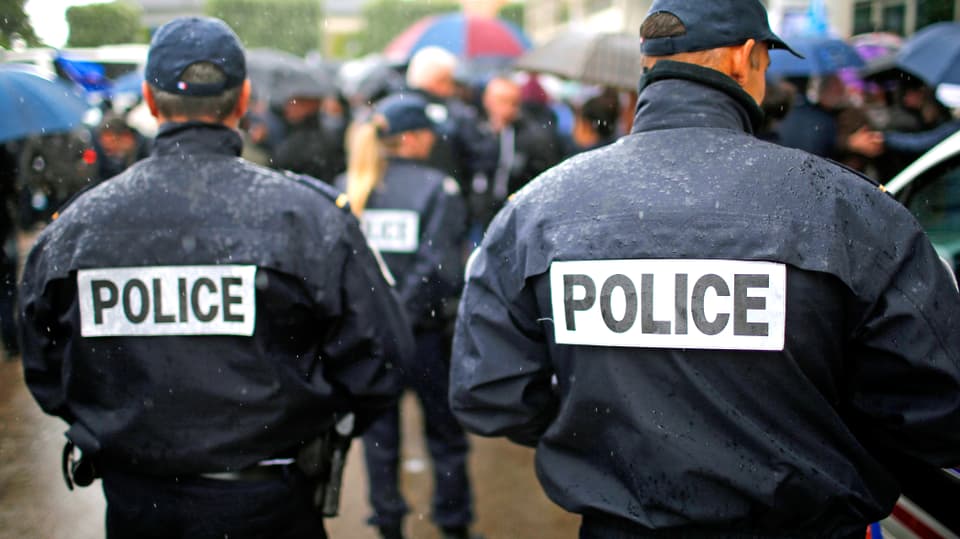 Zwei französische Polizeibeamten von hinten.