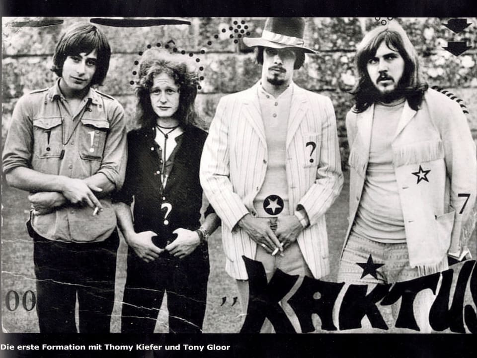 Schwarz-weiss-Bild von vier altmodisch gekleideten Rockmusikern 