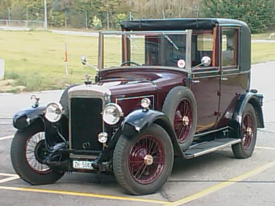 Ein weinroter Daimler aus dem Jahr 1923 steht auf einem Parkplatz.