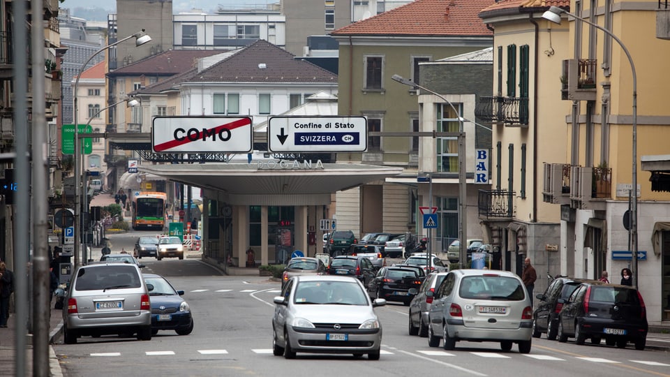 Die Grenze zwischen Italien und der Schweiz, einige Autos wollen die Grenze zur Schweiz passieren. 