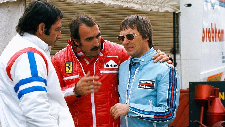 Clay Regazzoni (Mitte) mit Bernie Ecclestone (rechts) 1975, ganz links Carlos Pace.