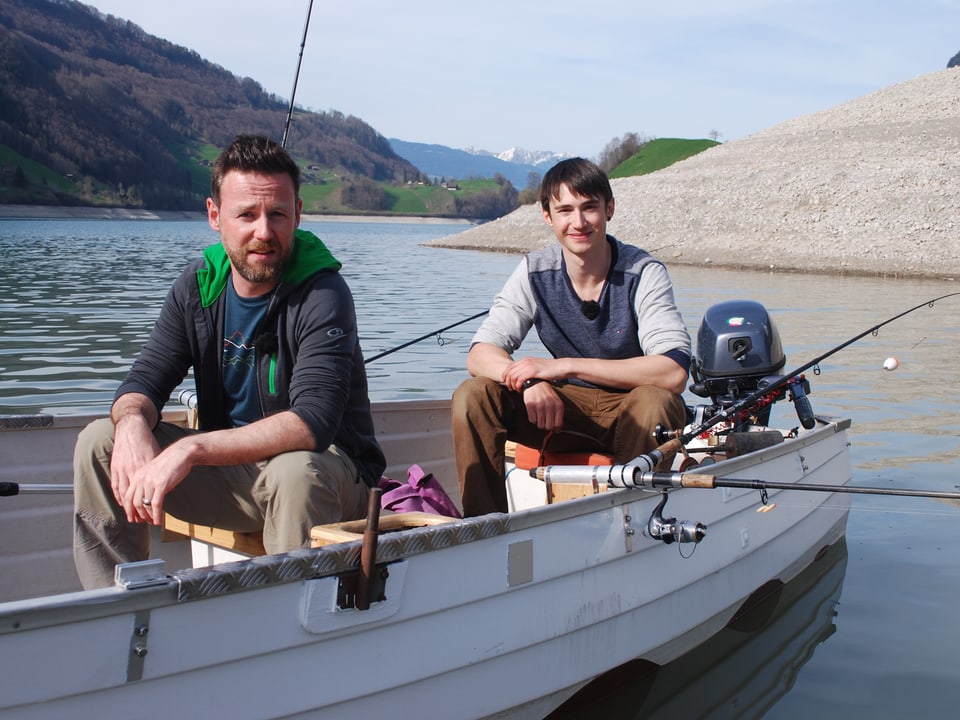 Nik Hartmann und Dominik Gasser am Angeln auf einem Boot. 