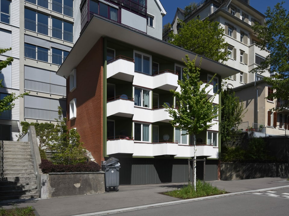 Ein Apartmenthaus mit weissen Balkonen.