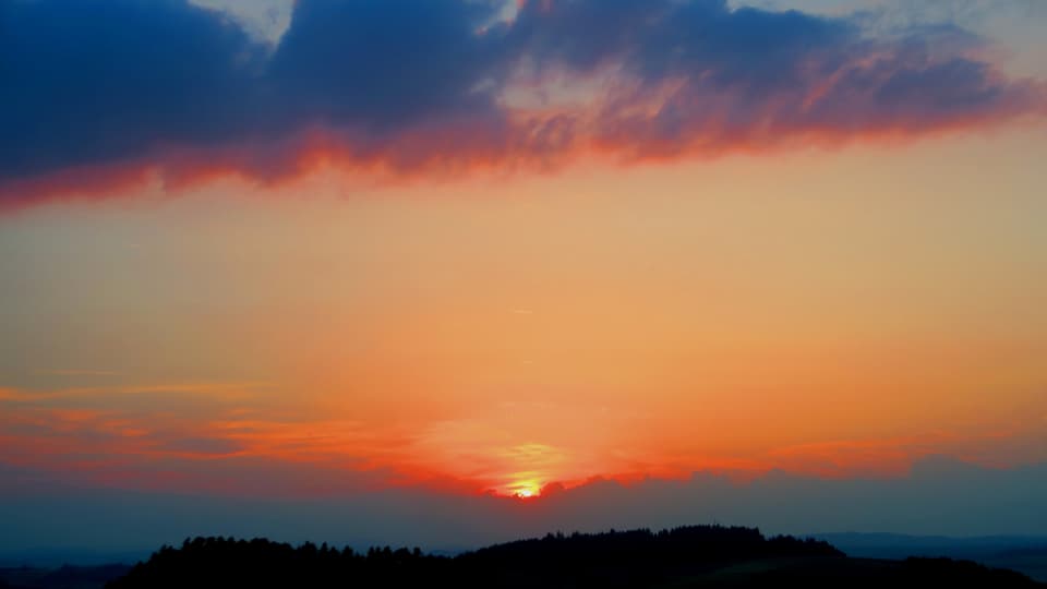 Sonnenaufgang mit ein paar rosaroten Wolken am Himmel bei Borisried BE.
