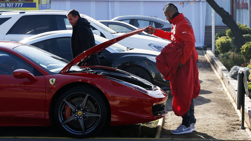 Vidal öffnet die Motorhaube seines Ferraris.
