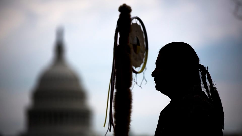 Mann in traditionellen Sioux-Kleidern vor Washington-Kapitol.