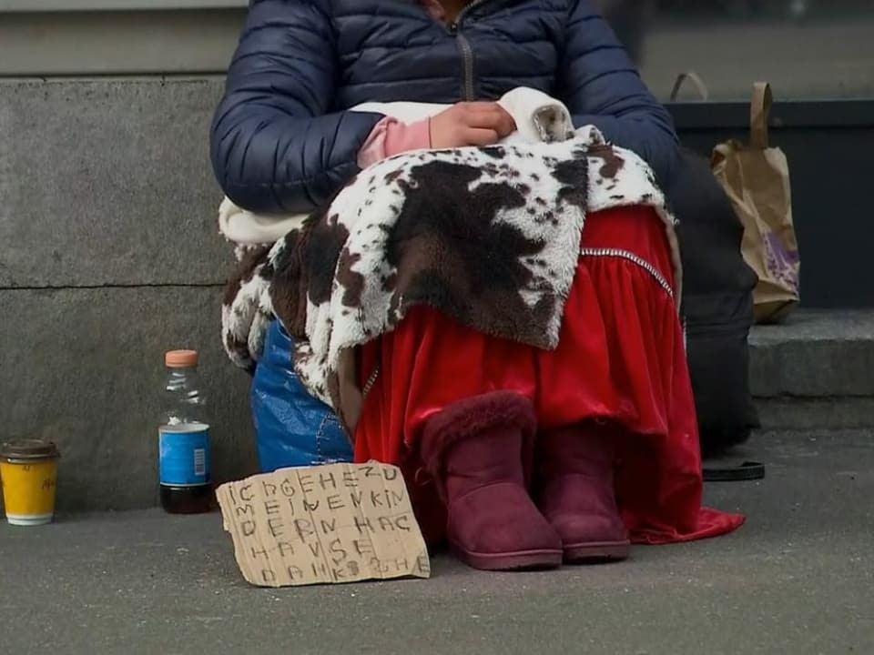 Frau am Boden mit Schild