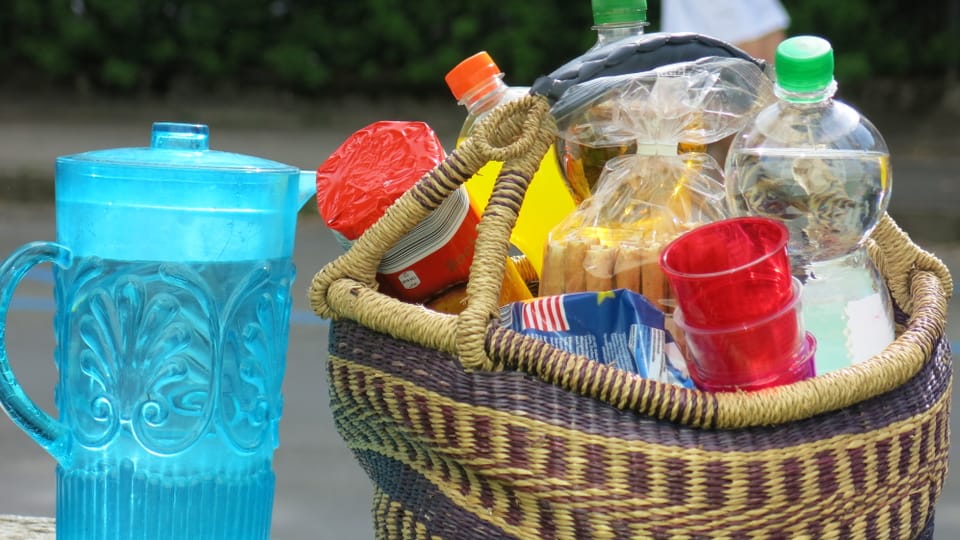 Ein Picknickkorb mit Getränken, Becher und Esswaren.