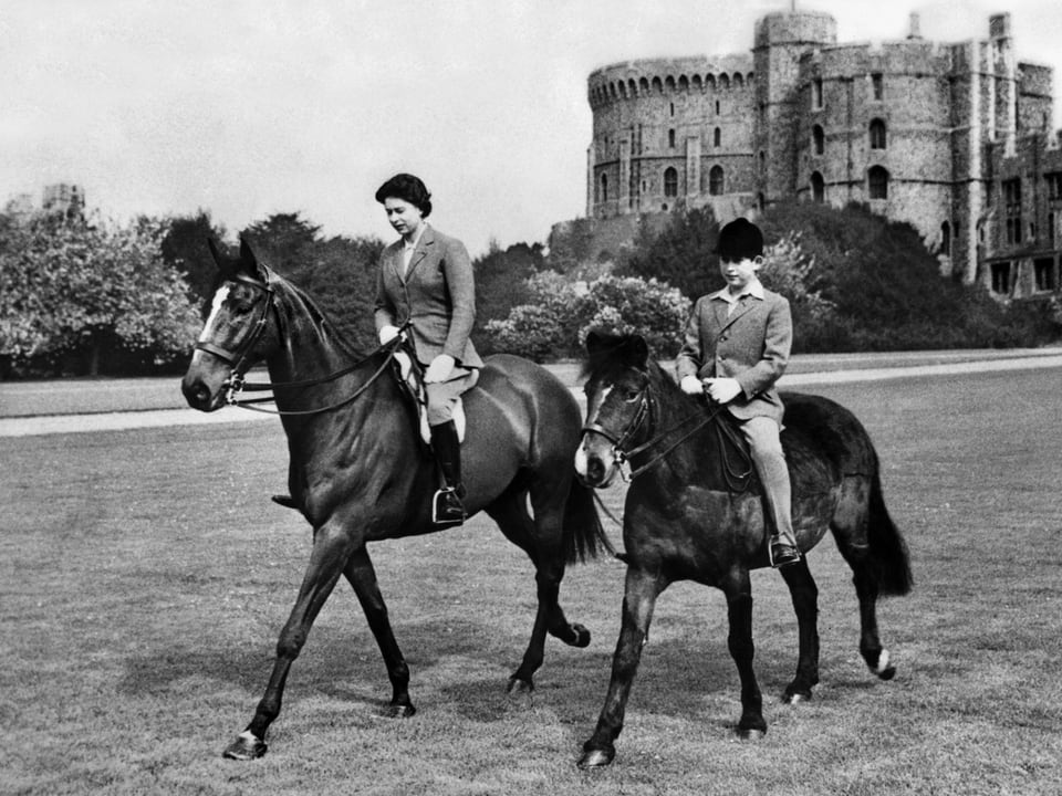 Königin Elizabeth mit Sohn Prinz Charles 1961 hoch zu Ross. 