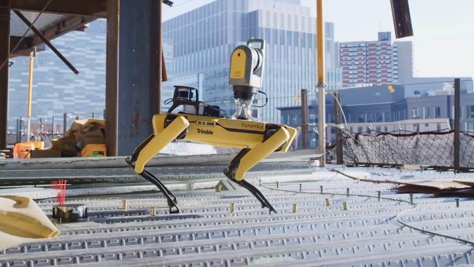 Roboterhund von Boston Dynamics auf einer Baustelle mit Stadthintergrund.