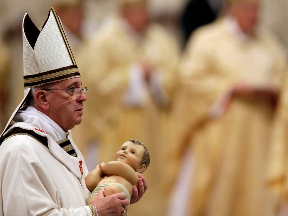 Der Papst trägt eine Jesus-Puppe.