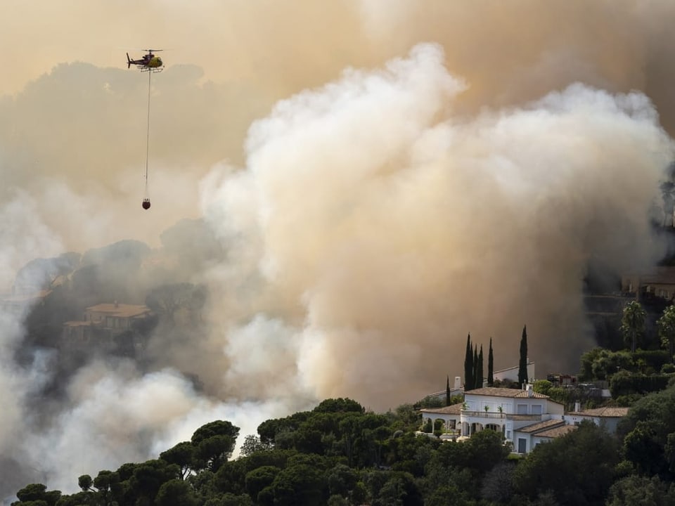 Ein Helikopter schüttet am 1. Juli Wasser auf einen Waldbrand in Santa Cristina d'Aro.