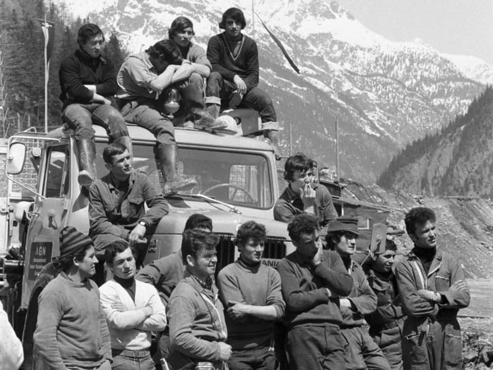 Gastarbeiter, die am Bau des Gotthard Strassentunnels beteiligt sind, posieren im Mai 1970 auf und vor einem Lastwagen.