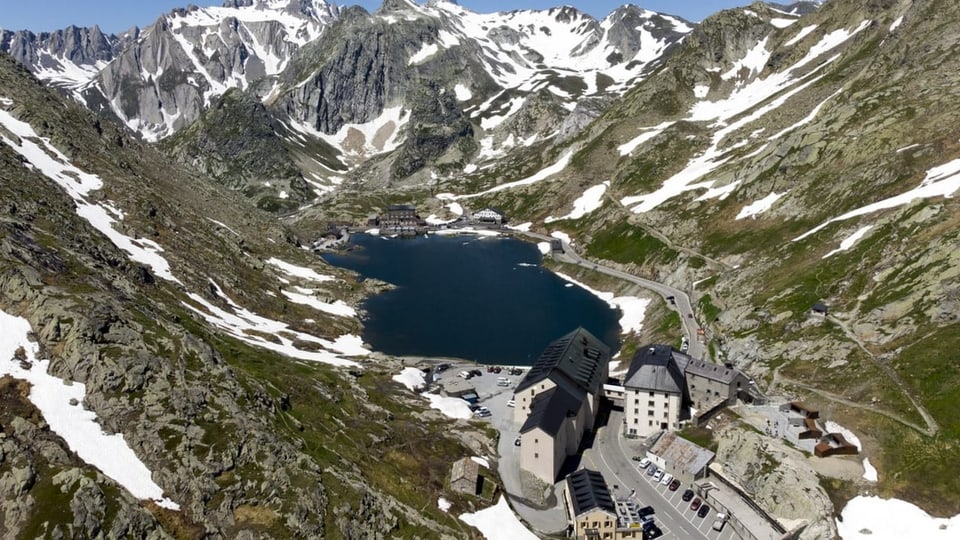 Das Hospiz auf dem Grand Saint Bernard mit See und Bergen.