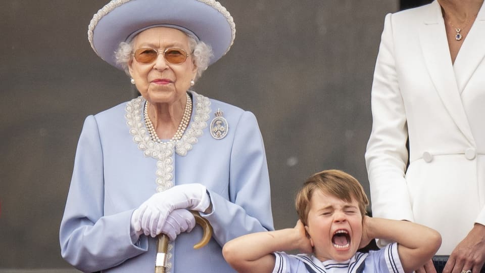 Queen Elizabeth neben ihrem Enkel, der sich schreiend die Ohren zu hält.