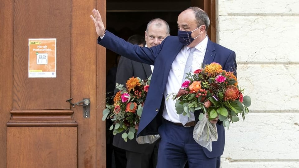 Markus Dieth mit Blumenstrauss, winkend vor der Eingangstür zum Regierungsgebäude in Aarau