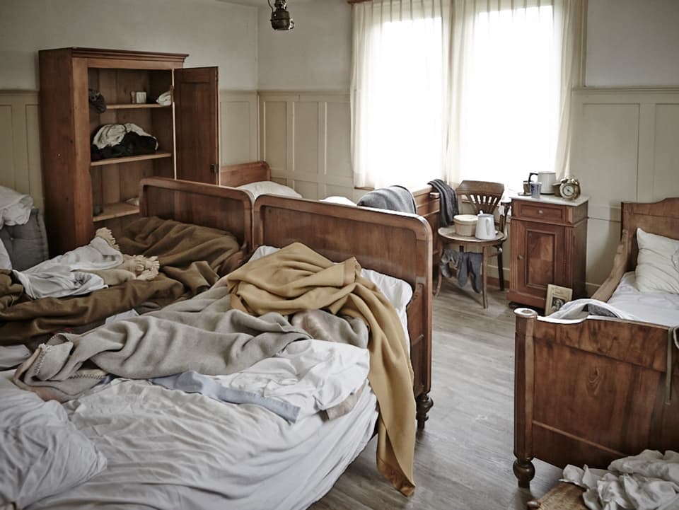 Schlafzimmer in Arbeiterwohnung, nicht gemachte Betten, Unordnung