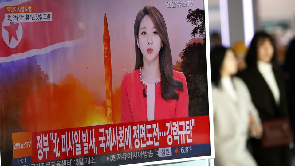 Sükoreanische Medien berichten über den Raketentest des Nordens: Auf einem Bahnhof in Seoul laufen Passanten an einem Fernseher vorbei. 