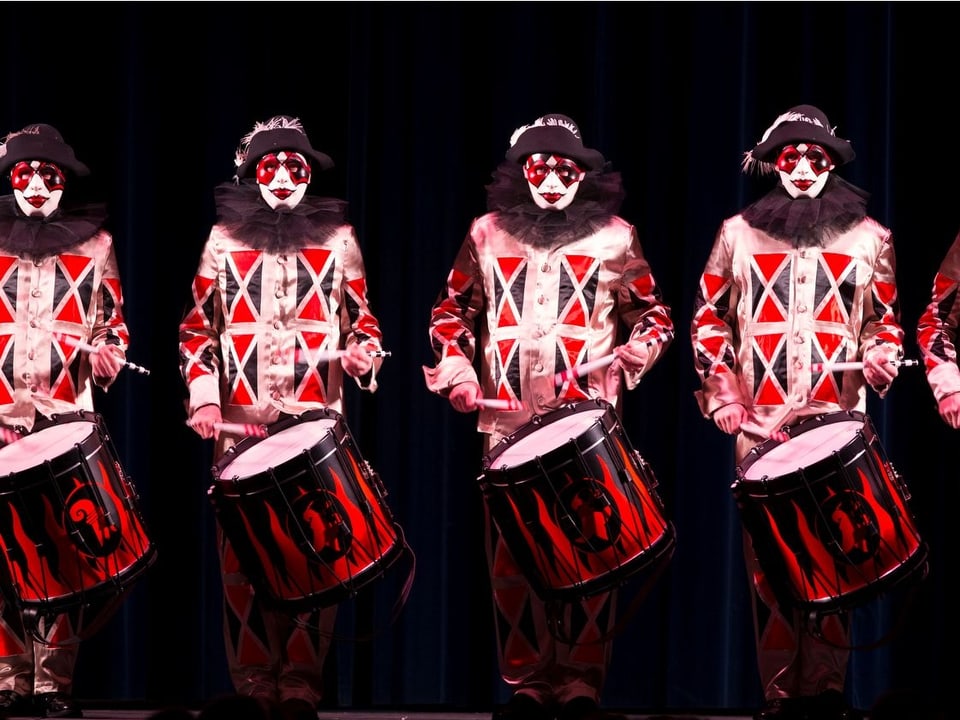 Vier Tambouren mit rot-schwarzen Trommeln.