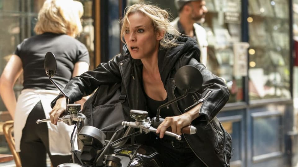 Eine Frau fährt auf einem Motorrad fährt durch eine Ladenpassage.