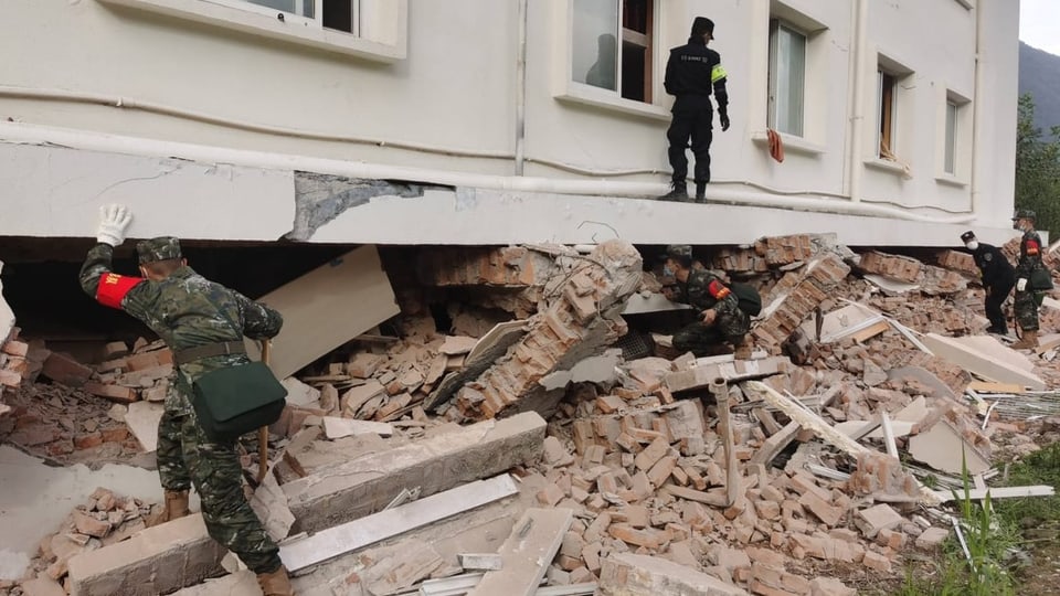 Rettungskräfte suchen unter zerstörtem Gebäude nach Überlebenden
