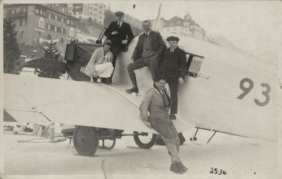 Vier Männer stehen in St. Moritz vor einem Flugzeug, Typ Junkers F 13 